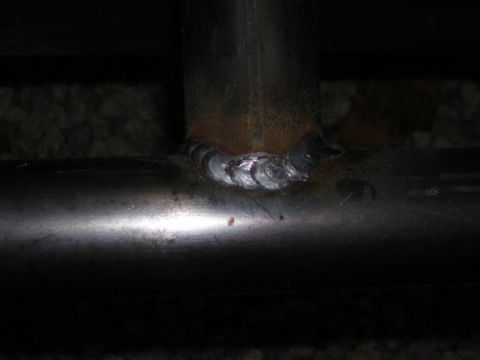 1995 Ford Bronco - Close-up of a metal weld joint on tubing, with visible rust and texture.