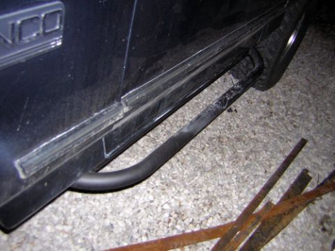 1995 Ford Bronco - The side of a 1995 Ford Bronco shows a tubular step attached below the door panel.