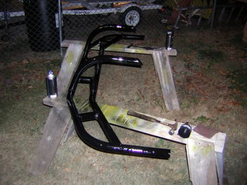 1995 Ford Bronco - Metal tubing structure being worked on outdoors, with spray paint and tools present.