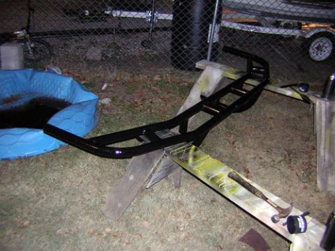 1995 Ford Bronco - A black aftermarket bumper is shown resting on sawhorses outdoors.