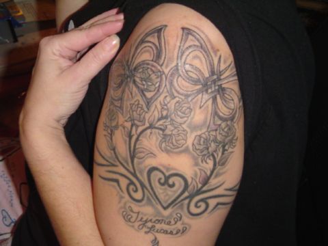 1993 Ford Bronco - Tattoo art on an arm features roses, a heart, and names.