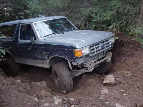 1987 Ford Bronco - This 1987 Ford Bronco is shown on a rough, wooded trail with its front bumper missing.