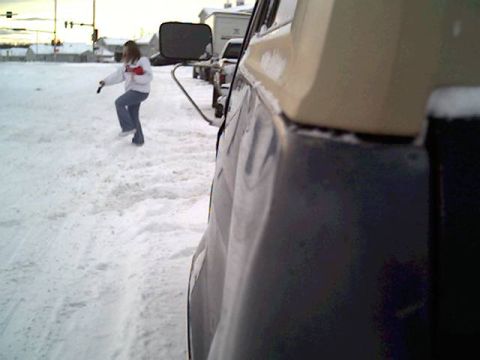 1987 Ford Bronco - A person stands in the snow next to a vehicle, with other vehicles visible in the background.