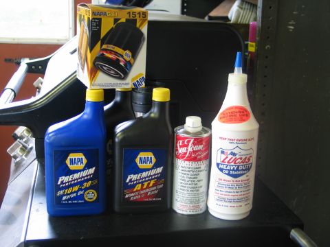 1995 Ford Bronco - A collection of automotive fluids and a NAPA oil filter are displayed, suggesting maintenance or repair work.