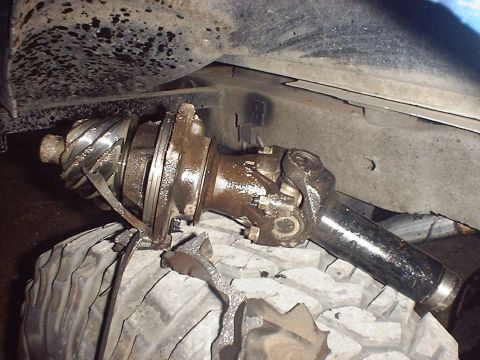 1988 Ford Bronco - This damaged differential and axle assembly appears to have been removed from a vehicle for repair or replacement.