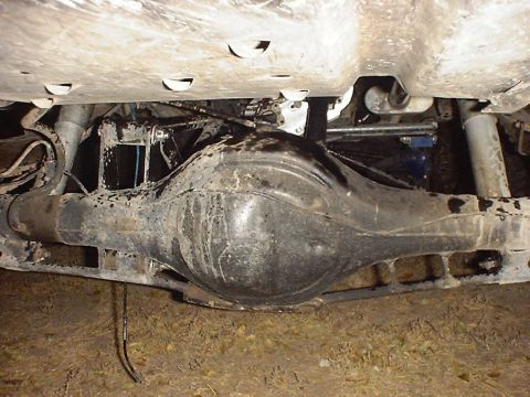 1988 Ford Bronco - The underside of a vehicle shows the rear differential and suspension, with some visible fluid leaks.