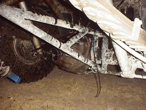 1988 Ford Bronco - The undercarriage of a heavily modified off-road vehicle shows large tires and robust suspension components.