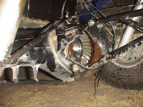 1988 Ford Bronco - The rear differential appears to have sustained significant damage, with gears exposed and fluid leaking.