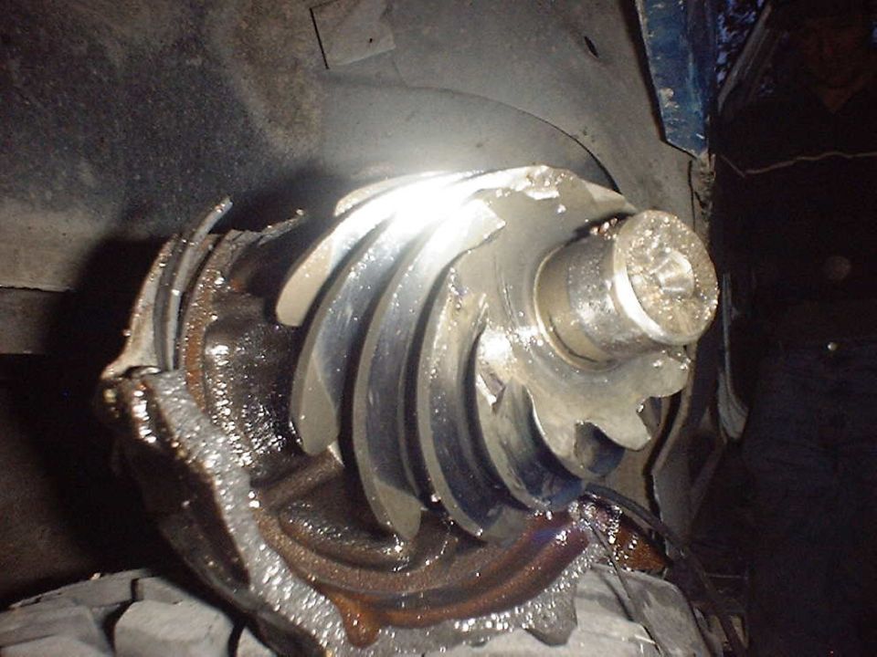 Damaged differential gear with broken teeth, covered in grease