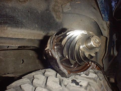 1988 Ford Bronco - A severely damaged differential gear is visible, resting on a tire, indicating a significant mechanical failure.