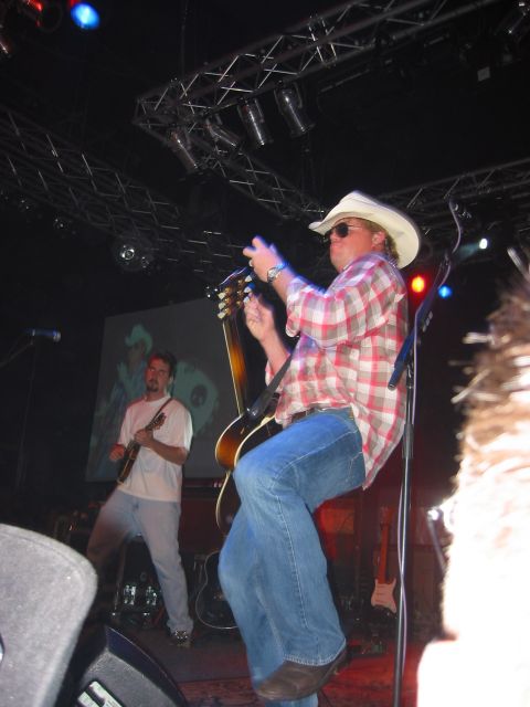 1989 Ford Bronco - Musicians perform live on stage, with one guitarist in a cowboy hat and plaid shirt.