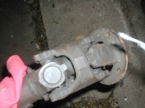 1979 Ford Bronco II - Close-up of a driveshaft U-joint, with a pink cloth and Supermotors.net branding visible in the frame.