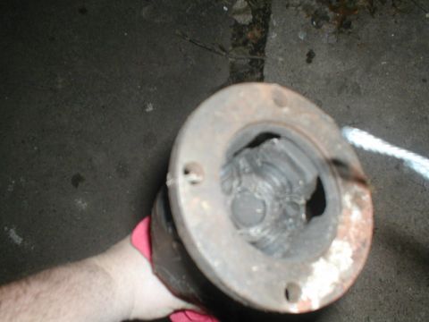 1979 Ford Bronco II - A driveshaft U-joint is held by a gloved hand, showing internal wear.