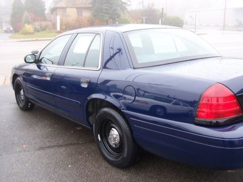 2001 Ford Crown Victoria - This dark blue sedan is seen from the rear quarter angle on a foggy day.