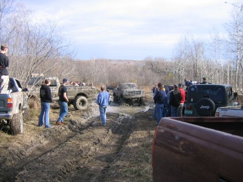 1994 Ford Bronco - Off-road vehicles navigate a muddy course during an event.