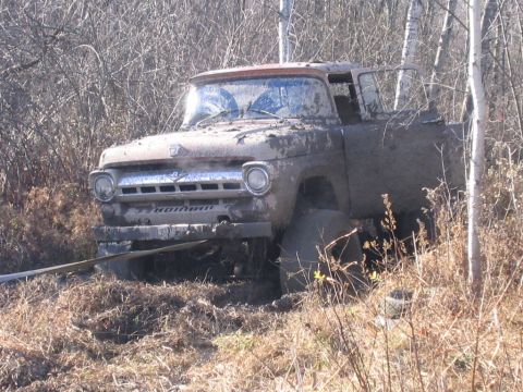 1994 Ford Bronco - This old Ford truck is deep in the mud and appears to be stuck in a wooded area.