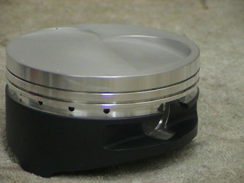 1979 Ford Bronco - Close-up view of a single piston, likely for an engine build, with visible ring grooves and a machined top surface.