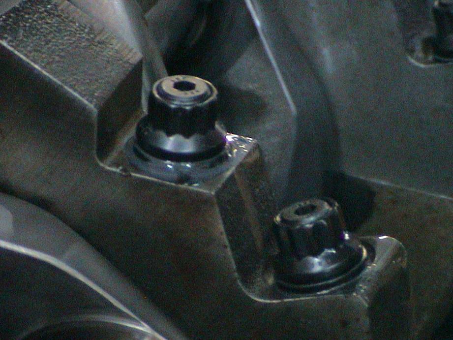 Close-up of engine block with two bolts visible