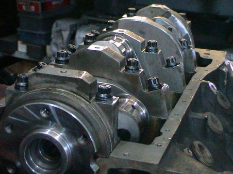 1979 Ford Bronco - Close-up view of an engine's crankshaft and block assembly, showing the bearing caps and bolts.
