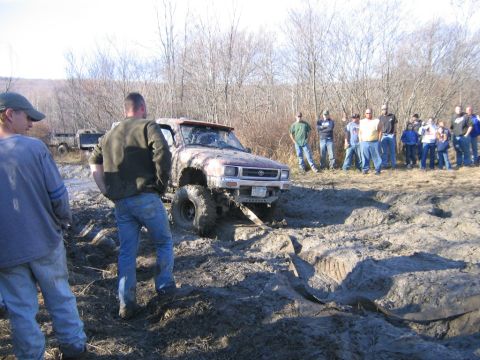 1994 Ford Bronco - Off-roaders watch as a Toyota pickup gets stuck deep in the mud during an event.