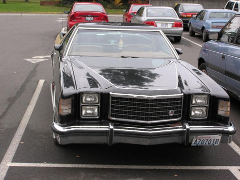 1973 Ford Ranchero - Front view of a 1977 Ford pickup truck parked in a lot with other vehicles.