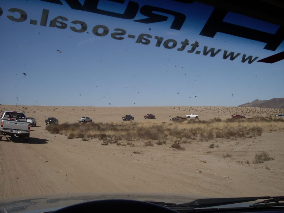 Several trucks driving in a desert landscape. Text on windshield reads www.offroad.com