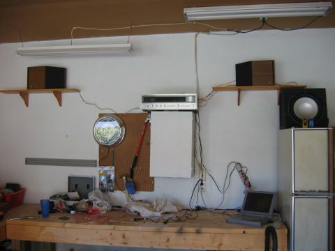 1985 Ford LTD Crown Victoria - A cluttered garage workbench displays various electronic components, tools, and a decorative clock.