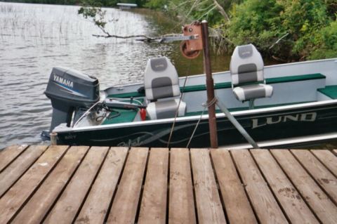 1996 Ford Bronco - A Lund boat with a Yamaha outboard motor is docked on a lake.
