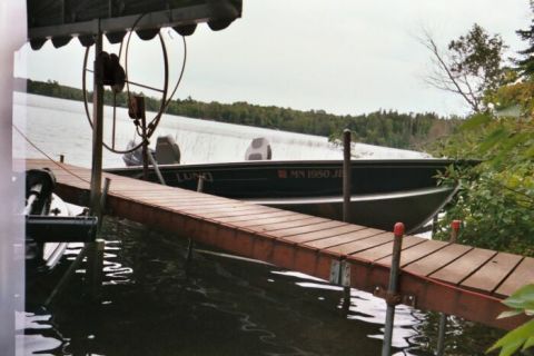 1996 Ford Bronco - A boat is docked on a lake with trees in the background.