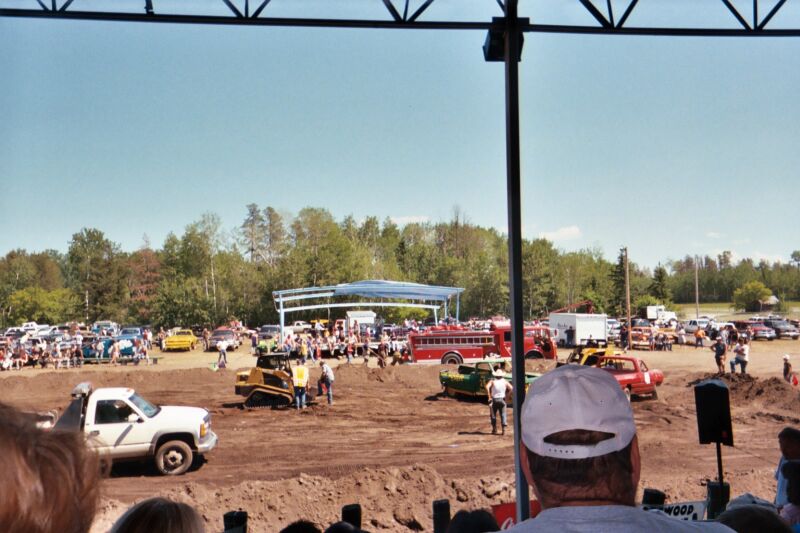 Demolition derby scene with a bulldozer, fire truck, and various cars