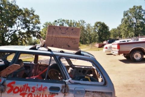 1996 Ford Bronco - This heavily modified station wagon, possibly prepared for demolition derby, displays 'Southside Towing' on its side and a hand-drawn sign…