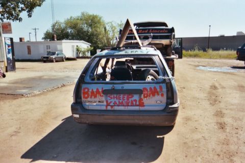 1996 Ford Bronco - A heavily modified car, prepared for demolition derby, is loaded onto a tow truck.