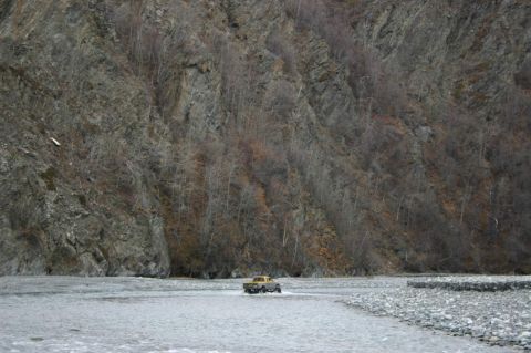 2003 Jeep TJ - Pickup truck navigates a river crossing in a mountainous, wooded area.