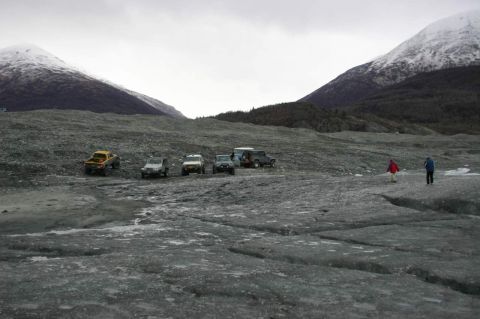 2003 Jeep TJ - Group of SUVs parked on a glacier, with two people walking in the distance.