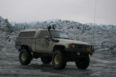 2003 Jeep TJ - This modified Toyota pickup truck, likely from the mid-1980s, is equipped for off-road exploration on a glacier.
