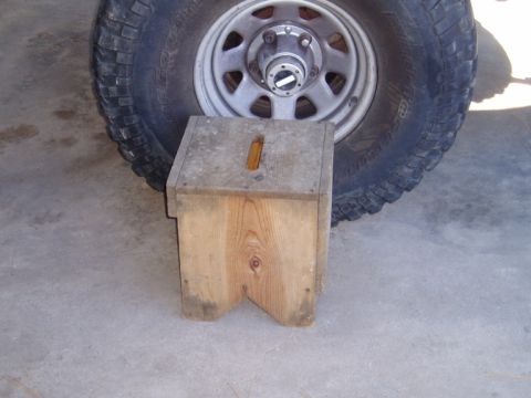 1990 Ford Bronco - A wooden block is placed under a vehicle's tire.