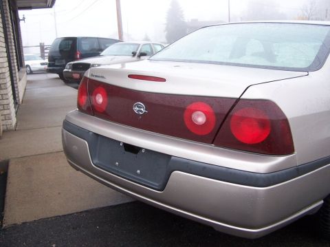 2001 Ford Crown Victoria - This gold sedan features a unique taillight design and an Impala badge on the rear.