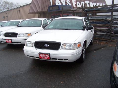 2001 Ford Crown Victoria - White 2001 Ford Crown Victoria police car parked in a lot with other similar vehicles.