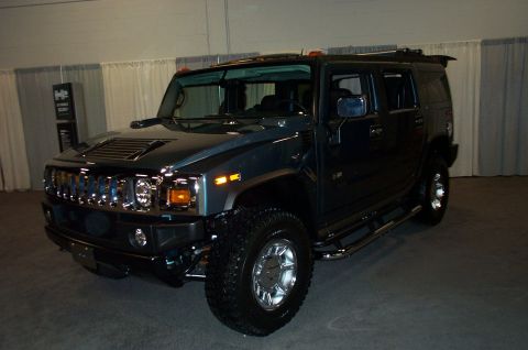 2001 Ford Crown Victoria - A Hummer H2 is shown from a three-quarter front view, parked inside a building with curtains in the background.