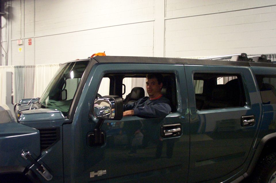 Dark green Hummer H2, driver's side view, man in driver's seat