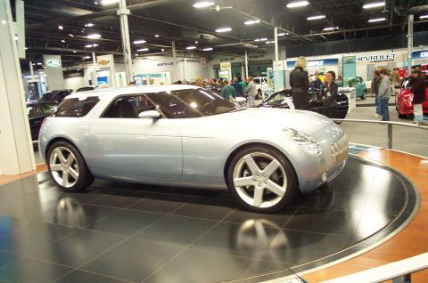 2001 Ford Crown Victoria - Concept car on display at an auto show, with other vehicles and people in the background.