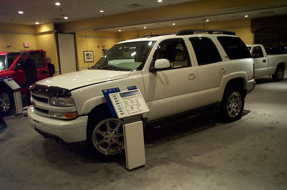 White SUV with display stand, 3/4 front view