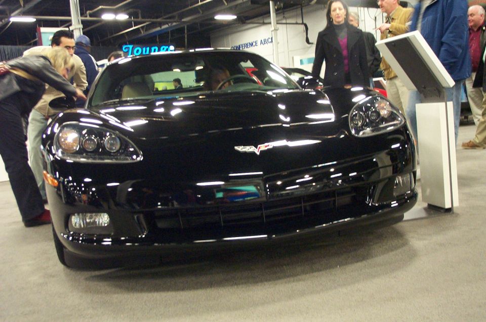 Black Chevrolet Corvette C6 front view at an indoor car show