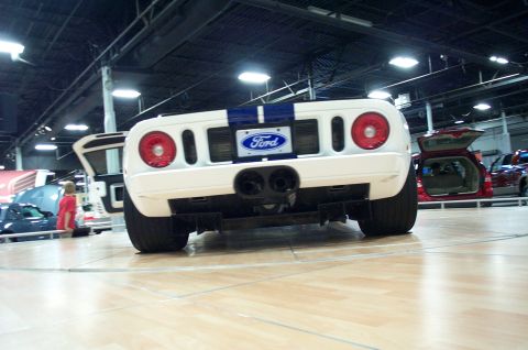 2001 Ford Crown Victoria - A white Ford GT is displayed indoors, with other vehicles visible in the background.