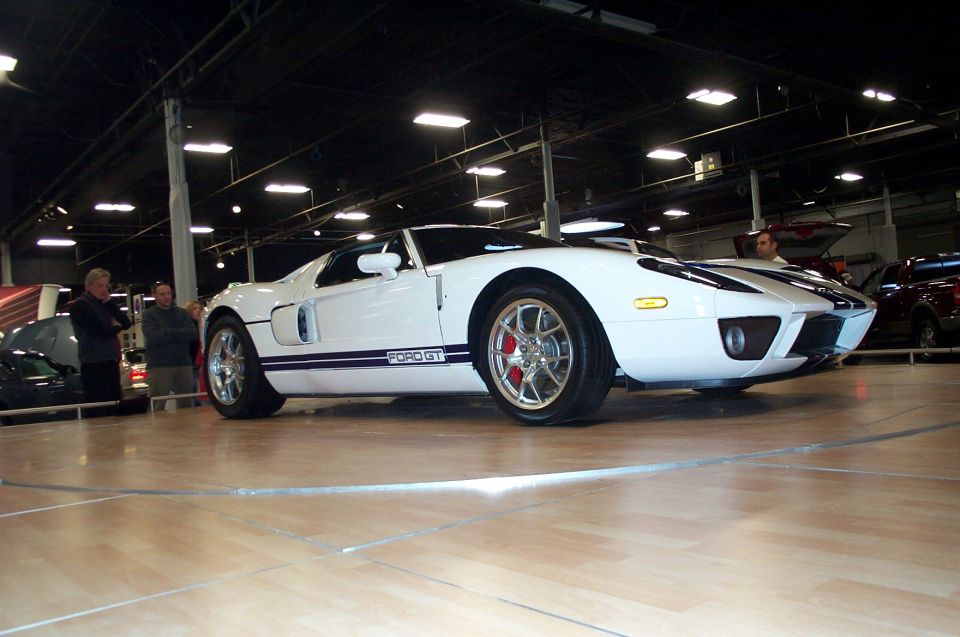 White Ford GT with blue racing stripes, side view showing "FORD GT" text on door