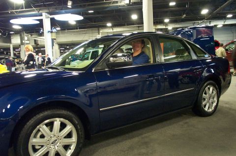2001 Ford Crown Victoria - A dark blue sedan is parked indoors, possibly at a car show, with a man visible in the driver's seat.
