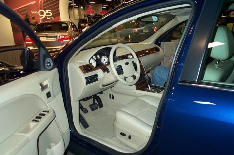 2001 Ford Crown Victoria - Interior view of a blue sedan, tan leather seats and wood accents on the dashboard and doors.