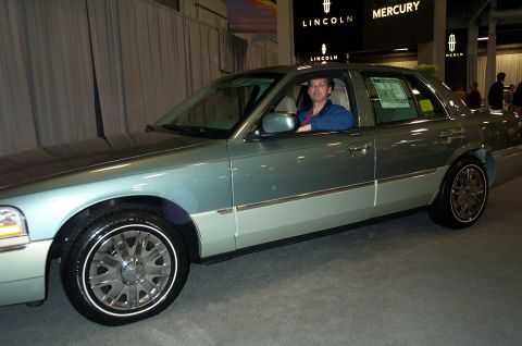 2001 Ford Crown Victoria - A person sits in the driver's seat of a 2001 Ford Crown Victoria at an auto show.