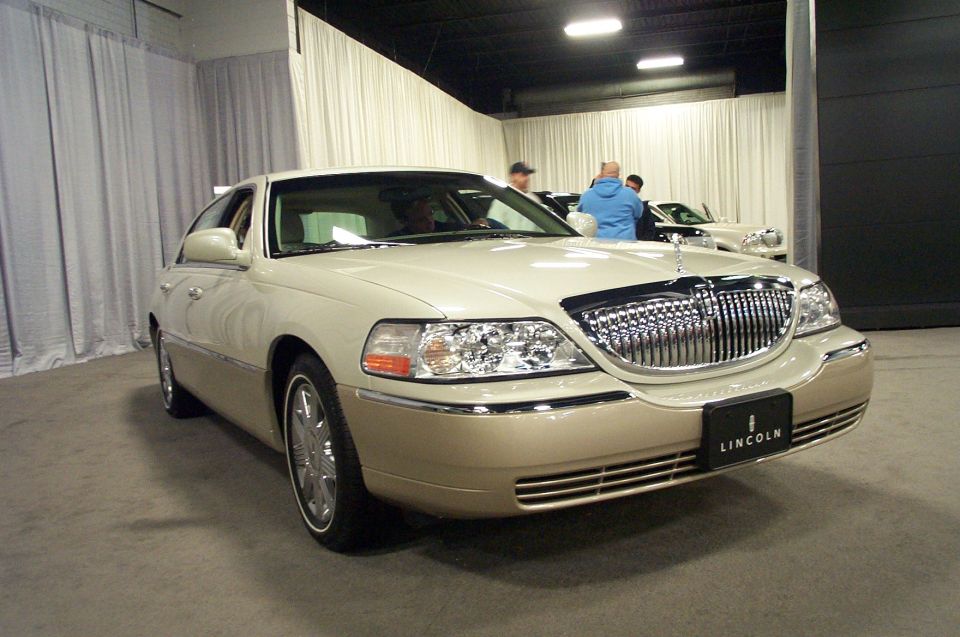 Cream and tan Lincoln Town Car with chrome grille and Lincoln emblem on front license plate
