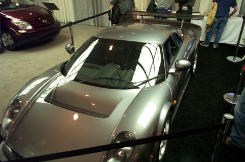 2001 Ford Crown Victoria - Silver sports car on display with a red car behind it.